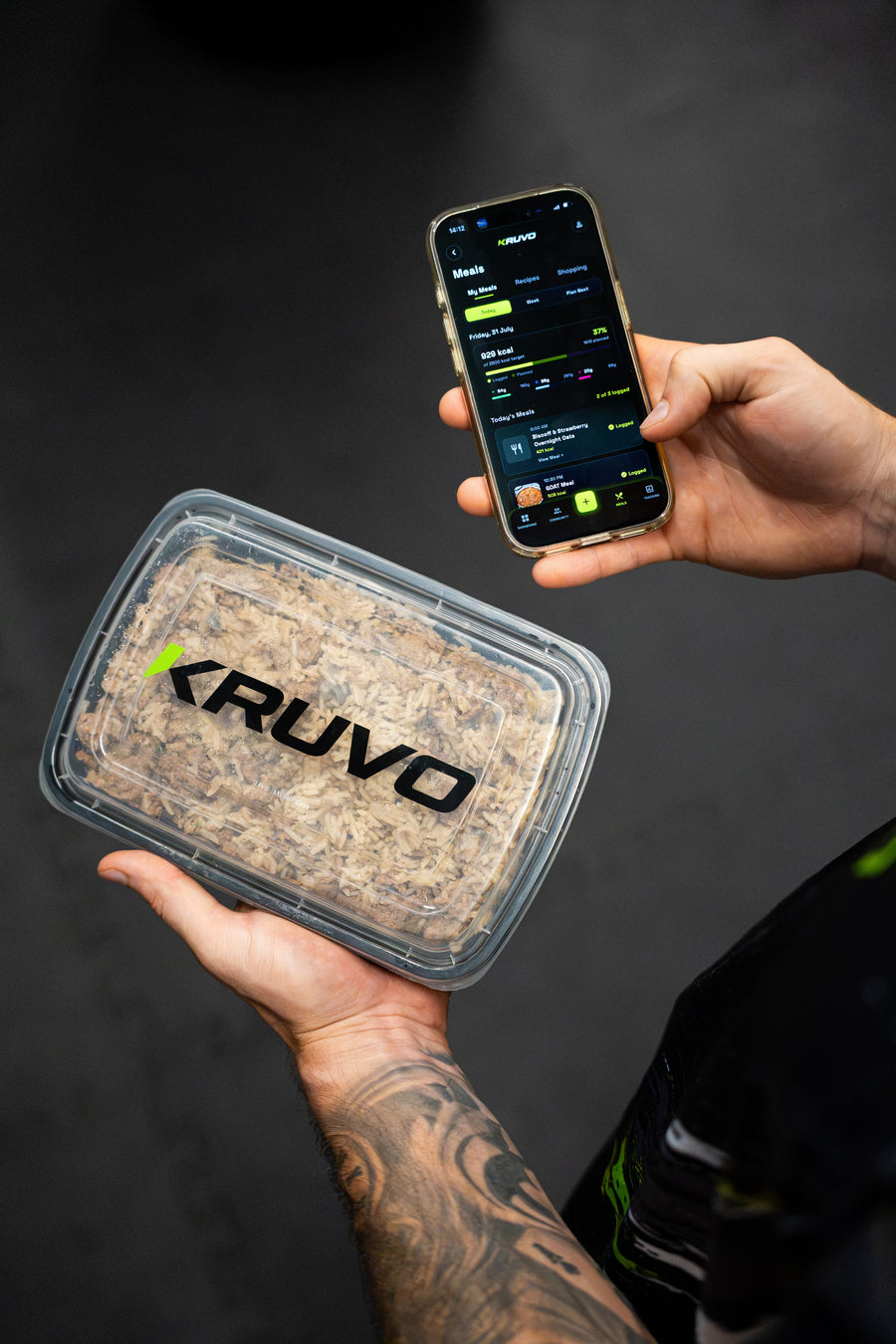 KRUVO meal prep container held next to a phone showing the KRUVO app